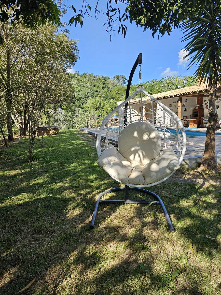 Espaço de descanso ao ar livre da Pousada Santa Júlia, com rede de balanço e piscina integrados à paisagem, no km 53 da Rota da Luz