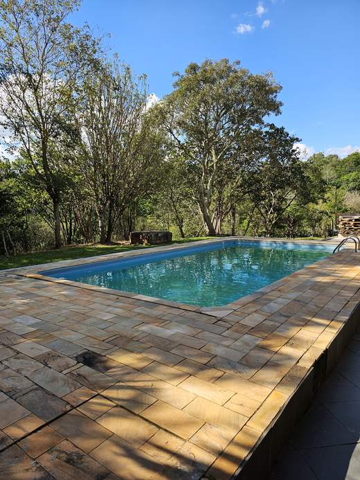 Piscina com deck de pedra na Pousada Santa Júlia